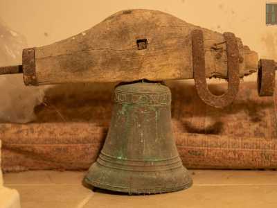 Ai piedi della cattedra troviamo invece la campana della chiesa, datata 1709 e ancora inserita nel suo supporto in legno